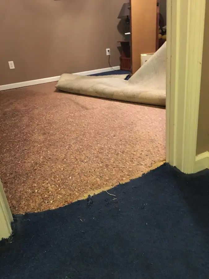 Carpet pad removal revealing water damage during Water Mitigation Services in Galloway